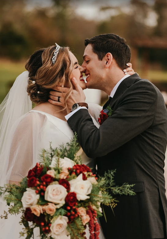 Couple shares a kiss at the barn wedding venues orlando cypress creek farmhouse.
