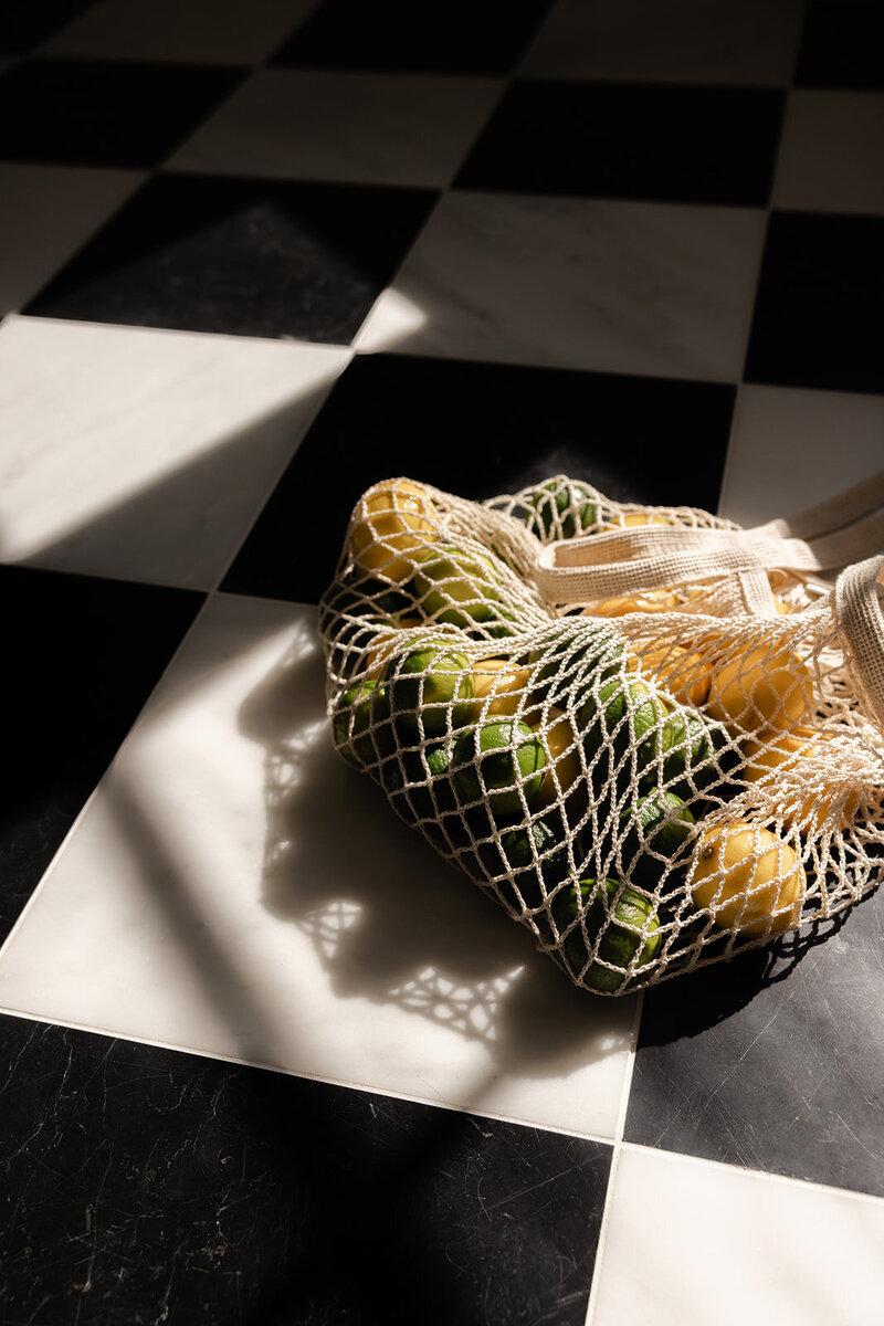Hormone-supportive lemons and limes in a basket on a checkered floor