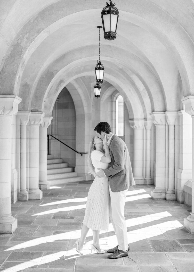 Black and white portrait of a couple walking through an arched stone hallway during a fine art wedding in Washington DC.