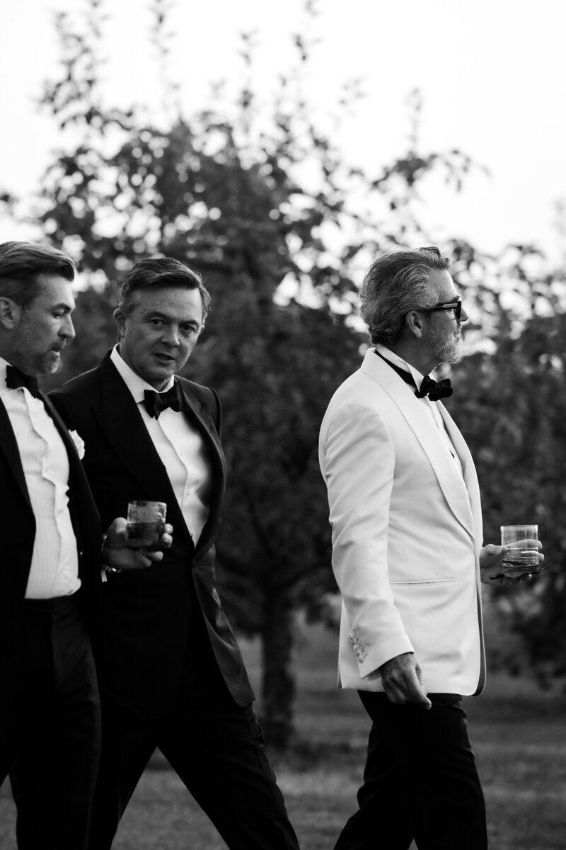 groom in white tuxedo kisses brides shoulder during speeches at Toronto bar wedding