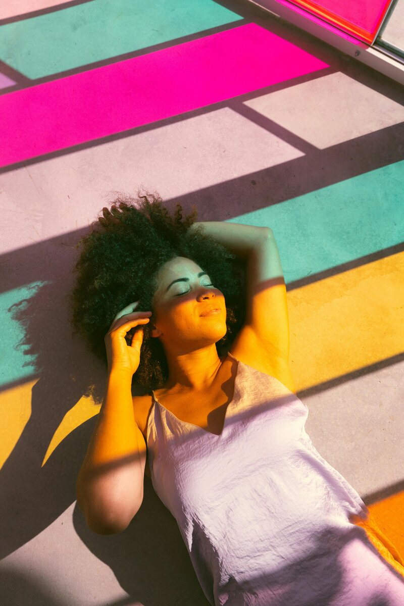 Light casting from a colorful wind over a smiling woman