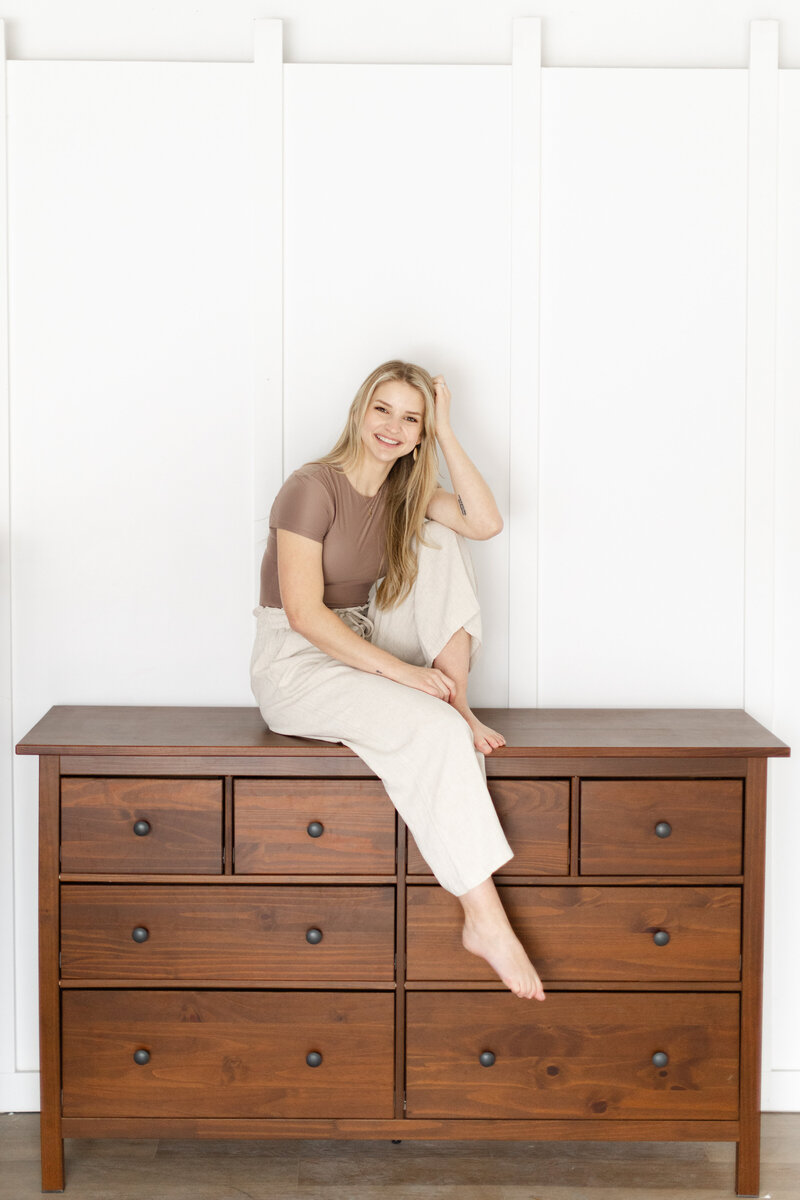 Sammie sitting on a wooden dresser