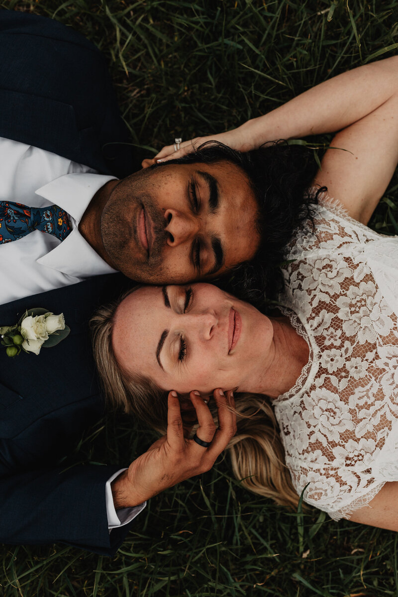 Bride and groom laying in grass in Cades Cove elopement