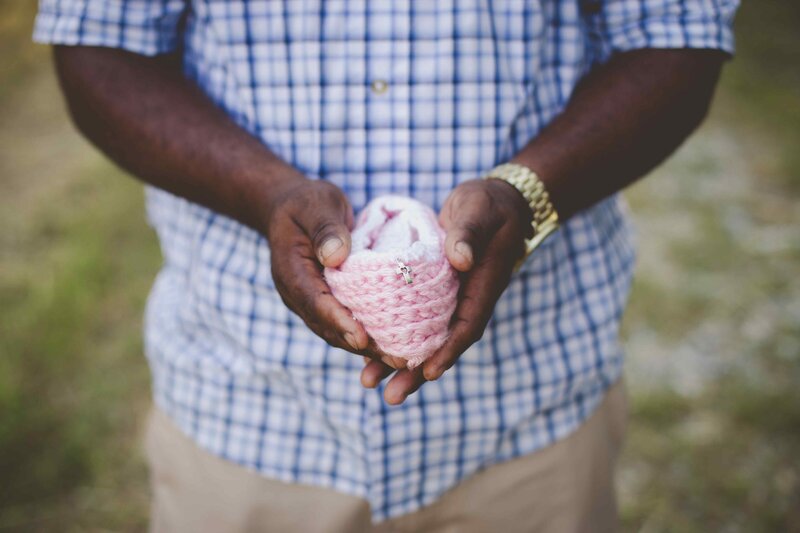 bereaved father holds knit crochet cradle in memory of baby girl in Heaven