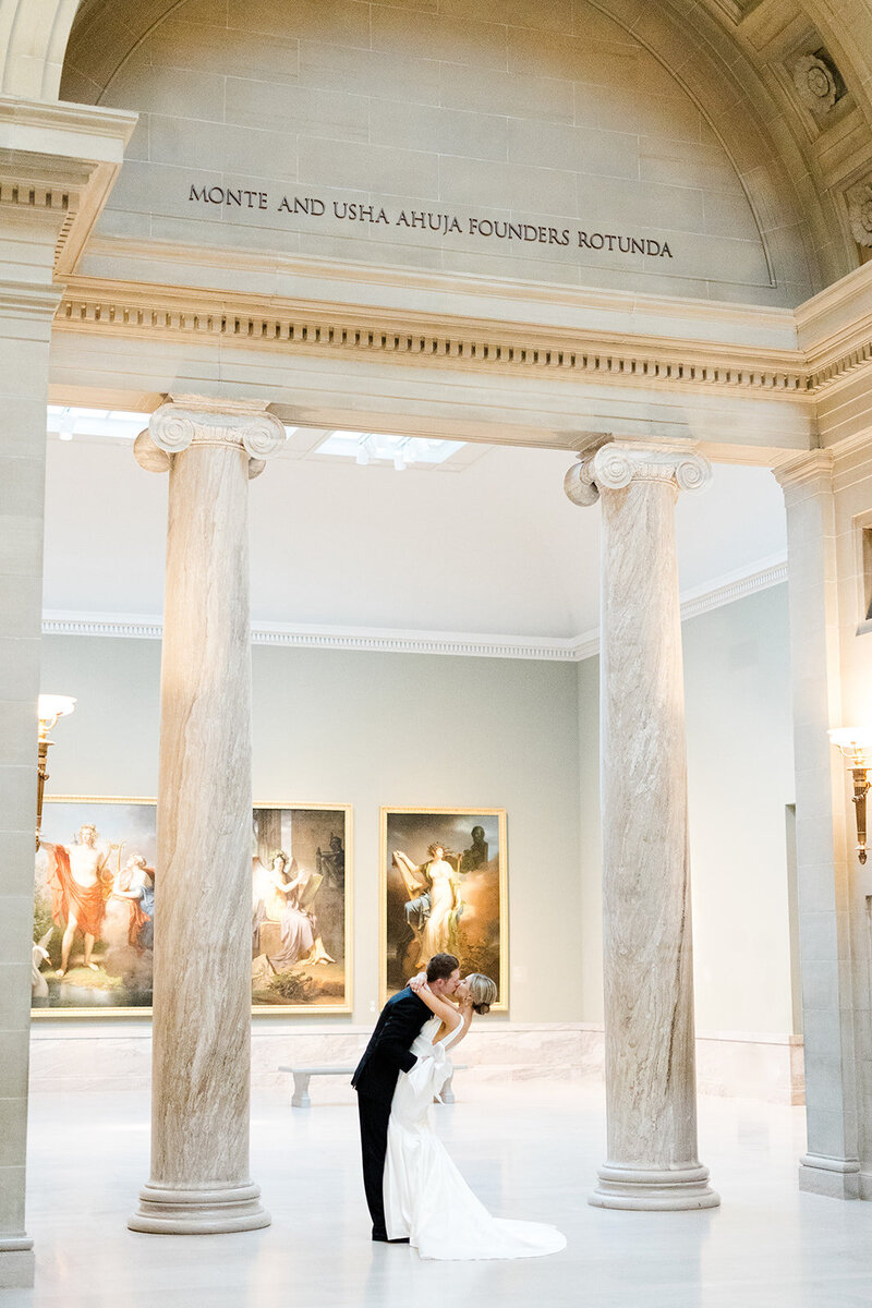 couple kissing in the cleveland museum of art on wedding day