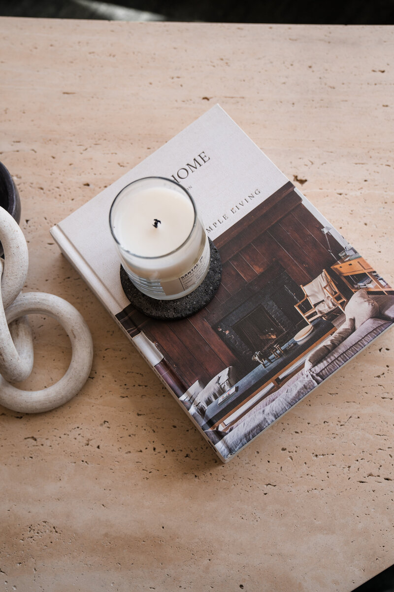 Candle sitting on a black coaster that's sitting on a home decor book
