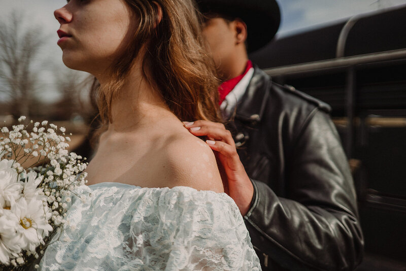 Alternative couple pose for their backyard elopement with a horse and cowboy hat.