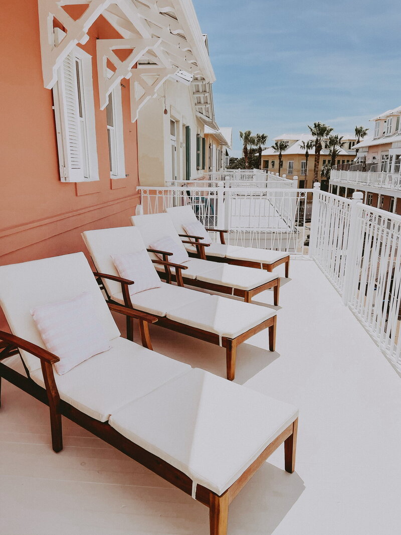 rooftop patio with white wooden lounge chairs