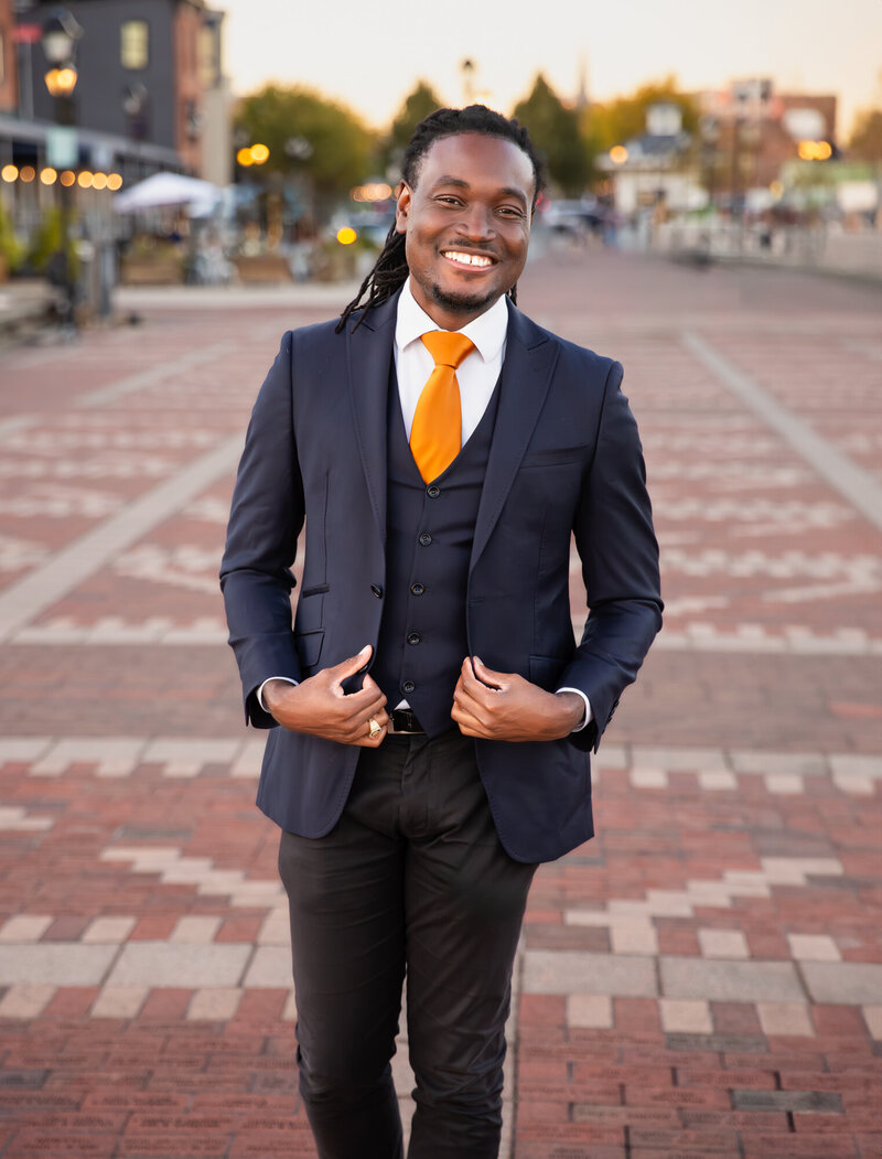 A-Black-Baltimore-Business-Owner-smiles-during-his-branding-headshots-at-Fells-Point-during-sunset-at-the-pier