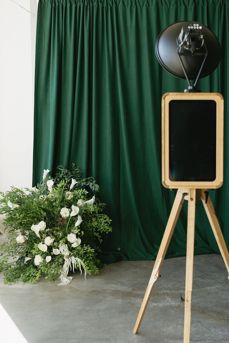 Wooden print photo booth for weddings in Ottawa, Montreal, and Toronto. Picture also includes wedding backdrop and florals