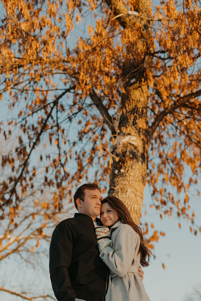 couple hugging to keep warm at sunset