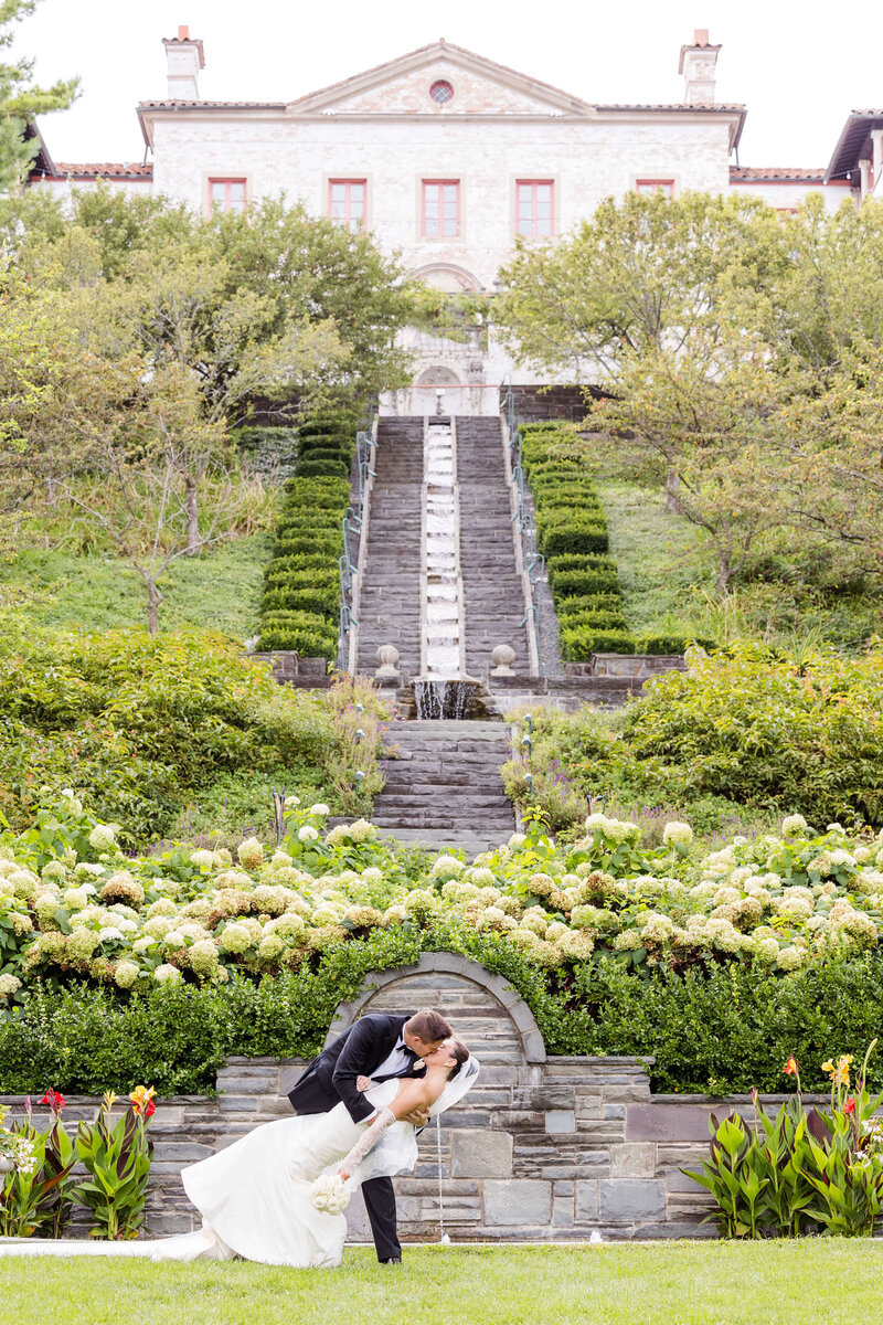 Couple dip kiss in front of fountains at the Villa Terrace in Milwaukee, Wisconsin