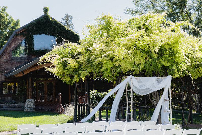 A wisteria wrapped gazebo is the backdrop for the wedding ceremony