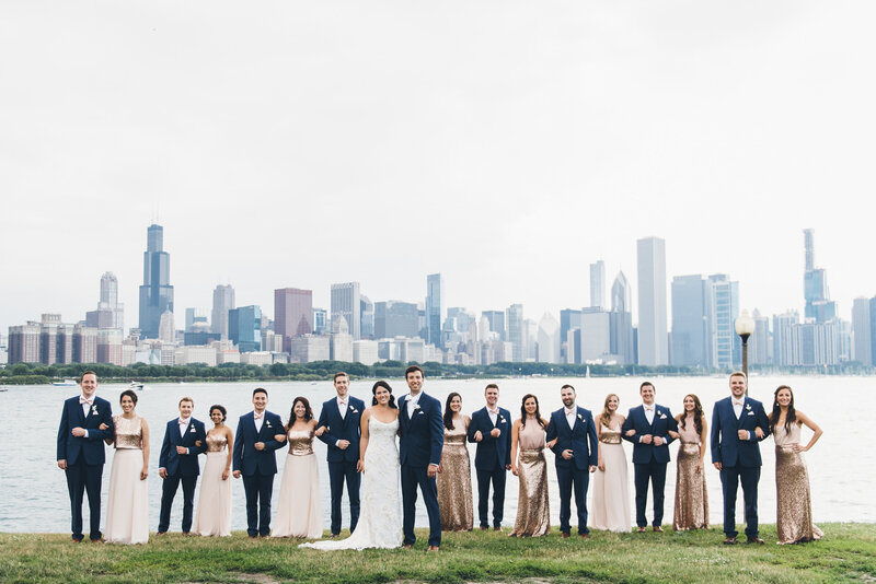 Wedding party with groomsmen in blue suits & bridesmaids in coordinating separates with the lakeshore and Chicago skyline