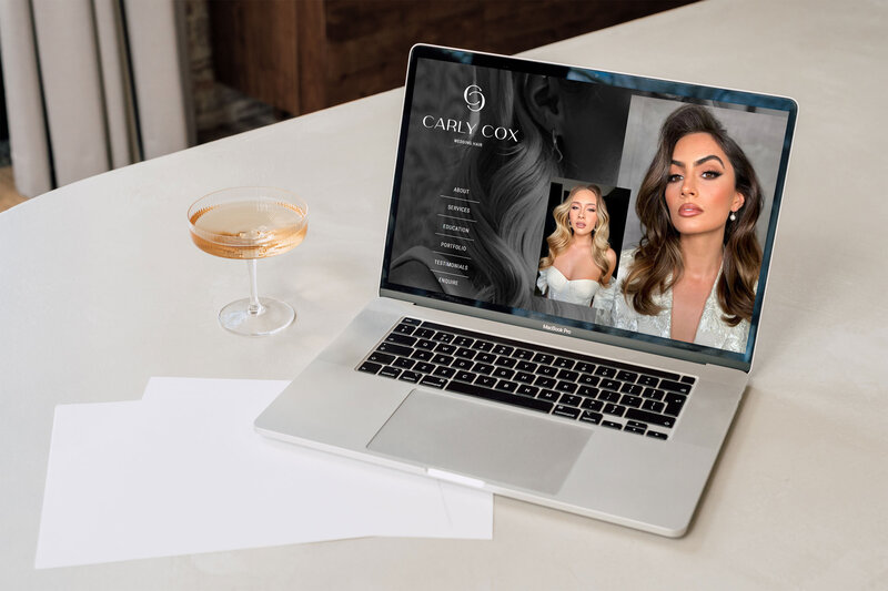 Laptop mockup of Carly Cox’s website styled with a drink — part of the chic brand presentation