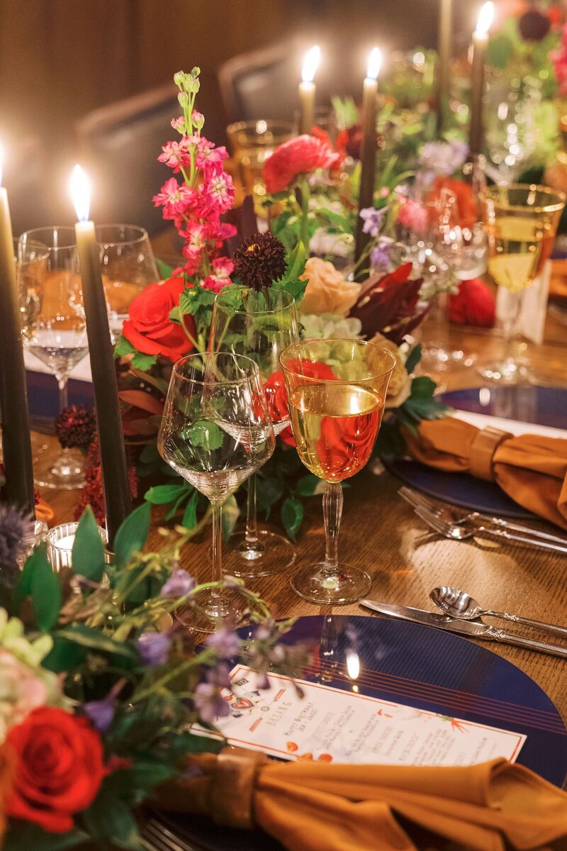 Reception table set with candles, glasses, and stunning floral arrangements