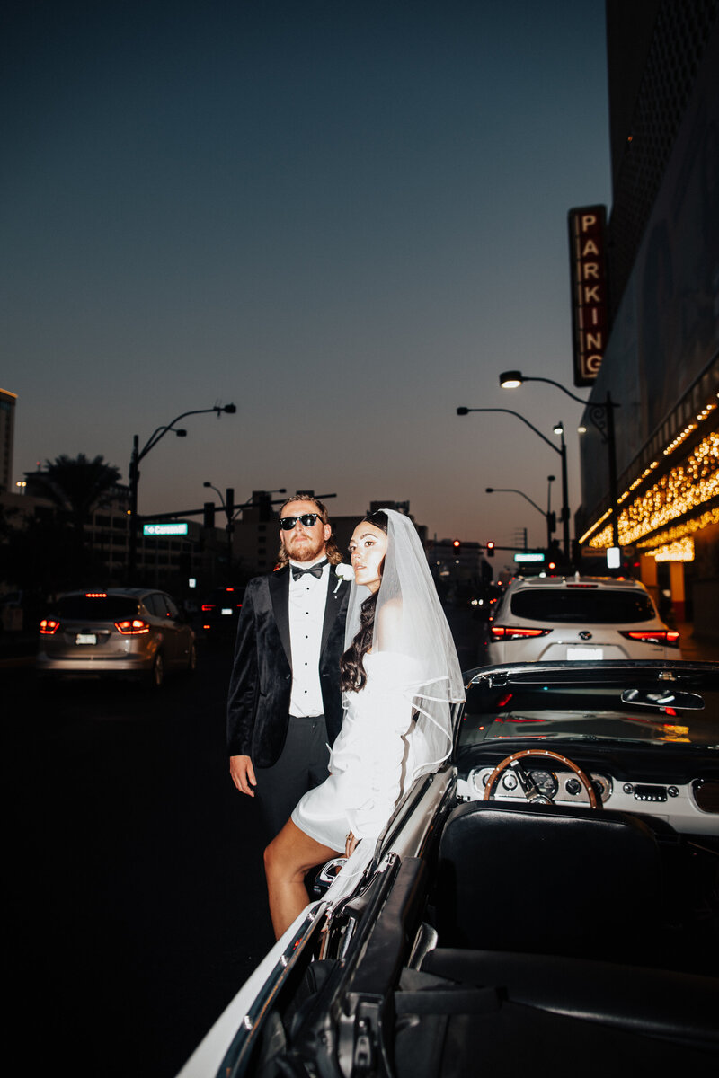 bride and groom partying in back of vintage car