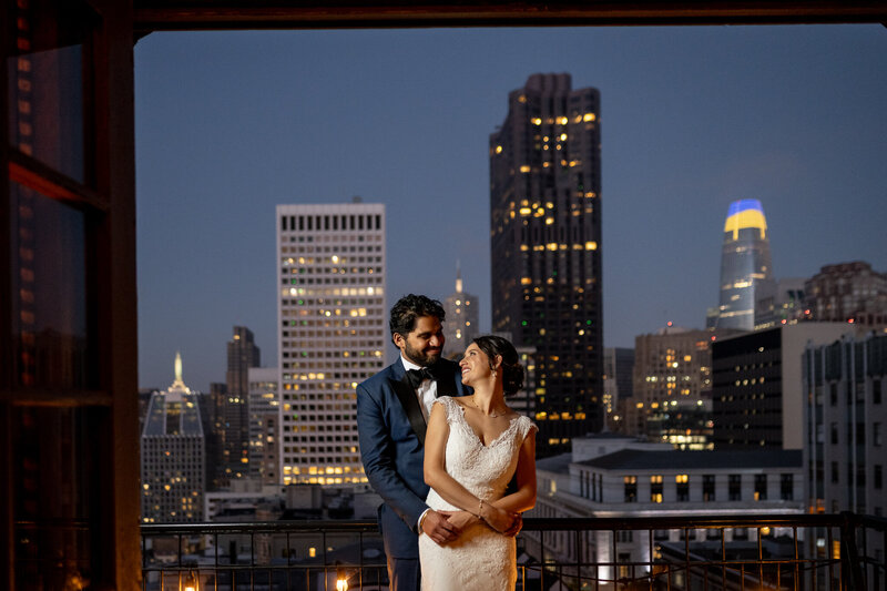San Francisco wedding photographer documents couple portrait on University Club rooftop with downtown skyline at twilight