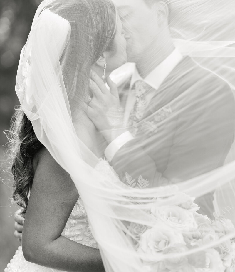 big sur california wedding, bride and groom kissing under a veil