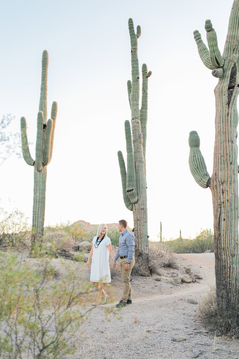 Couple walking in the Arizona desert with cactus