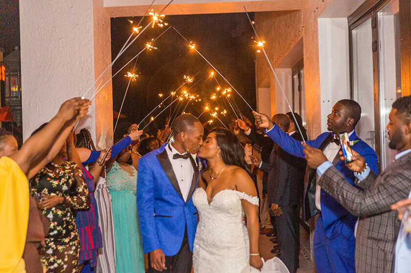 Bride and groom kissing during a sparkler exit at Crystal Plaza Ballroom in Fort Lauderdale, captured as part of their wedding photo timeline with a First Look.