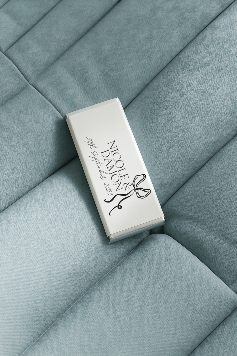 Elegant white personalised wedding chocolate bar by Barilliant, Australia's No.1 luxury custom chocolate brand, styled on soft blue fabric — perfect for modern wedding favours and bespoke event gifting.