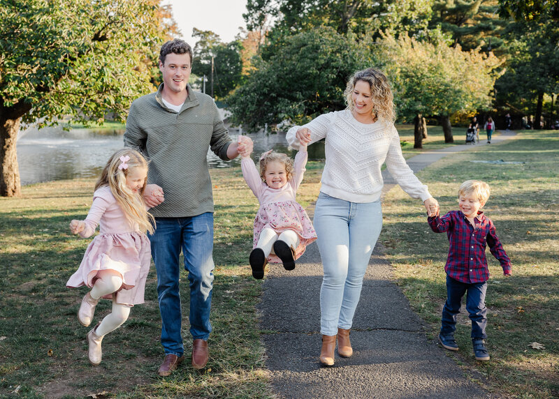 Lifestyle portrait of a family playing playing in an Essex County, NJ park.