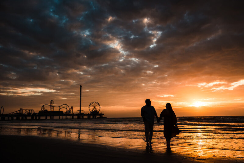 Couple's engagement session photo taken at Galveston Beach in Galveston, Texas.