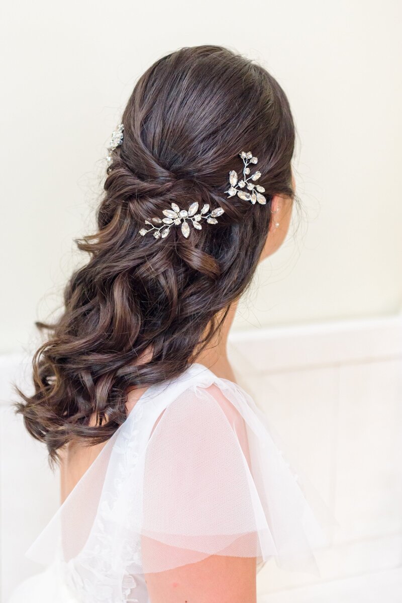 Medium length long hair is curled with silver flowers.