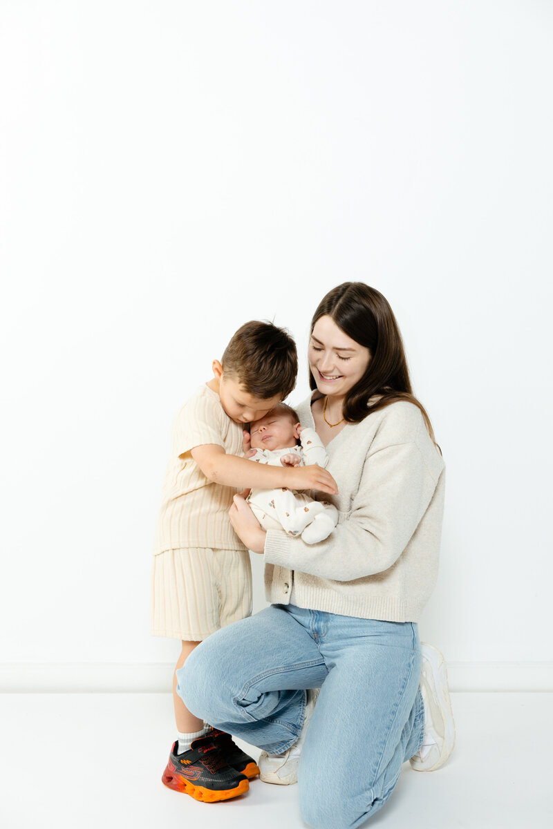 women holding a baby and a small child hugging