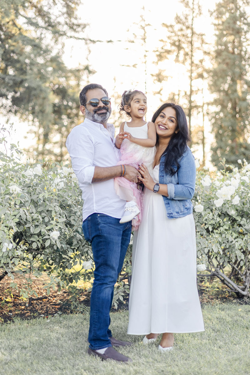 smiling-family-posing-golden-hour-rose-garden