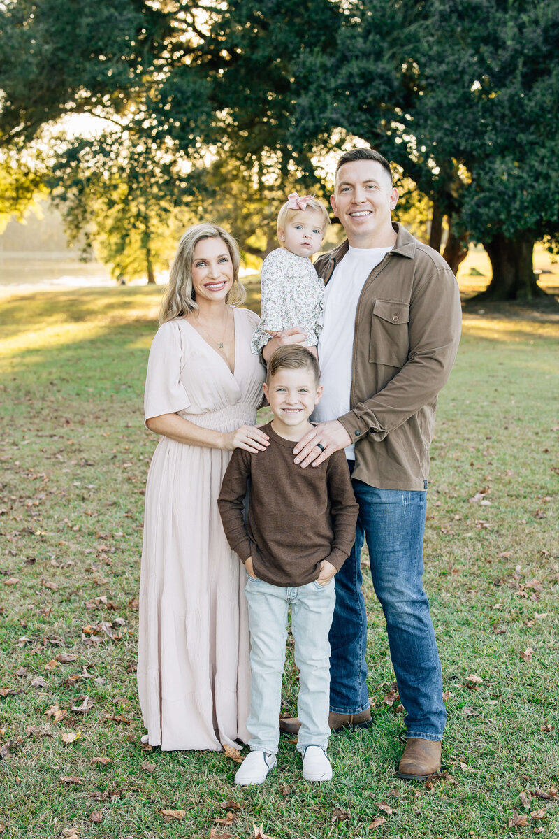 Family posing together smiling at camera in a field for mini model rep program