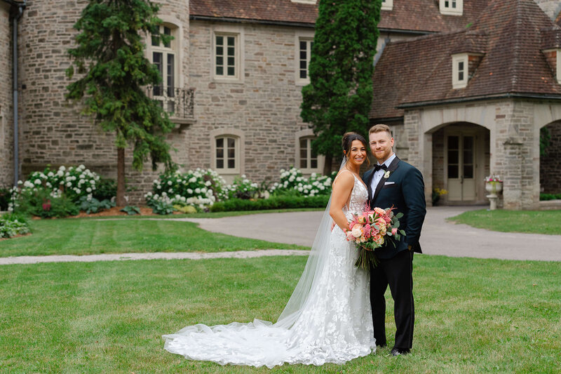 full length portrait of a bride in a white dress and groom in a black tux.  Taken at Eaton Hall by Ottawa wedding photographer JEMMAN Photographer