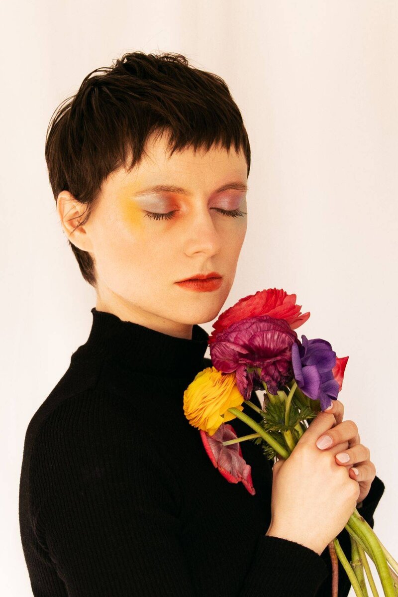 Portrait doux et coloré d'une jeune femme portant un bouquet de fleurs lors de sa séance portrait artistique à Lyon