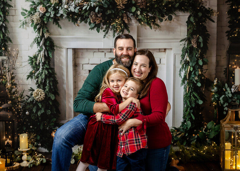 Family hugging at Allison Reilly's New Jersey photo studio while posing for holiday portraits