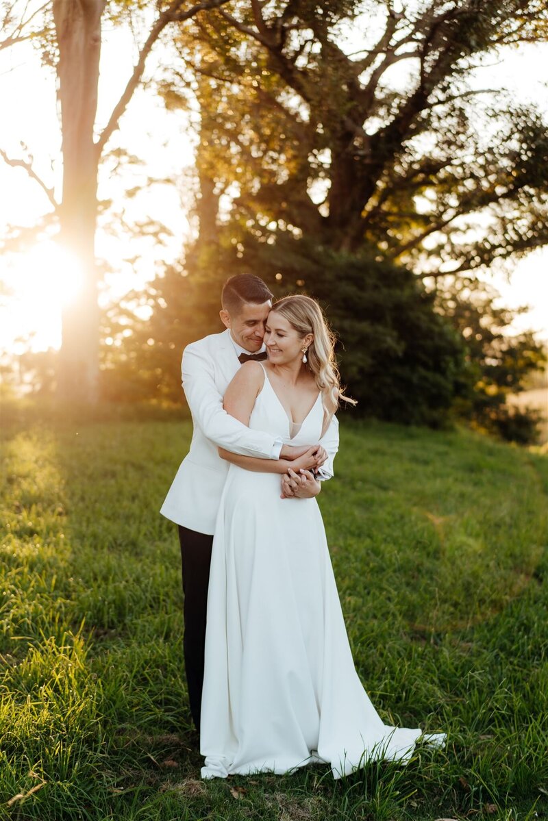 A bride and groom standing together at sunset during a wedding photoshoot at Narrows Landing being photographed by Waikato Wedding Photographer Haley Adele Photography