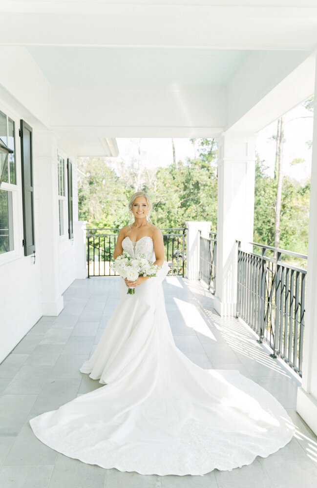 bride standing on the porch of the Coastal Arts Center