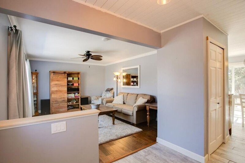 masculine and functional sitting area with a couch, guitars, and blue area rug