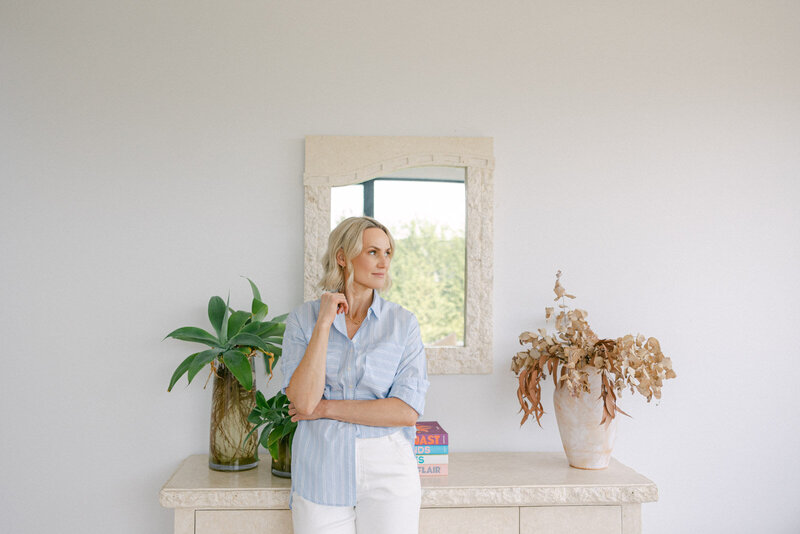 Zelda Green, money and mindset educator and podcaster, gazing off camera whilst looking relaxed in a light blue shirt