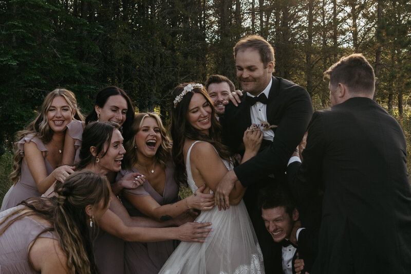 wedding party embracing bride and groom