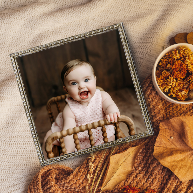 Adorable six month old baby girl sitting in a little crib