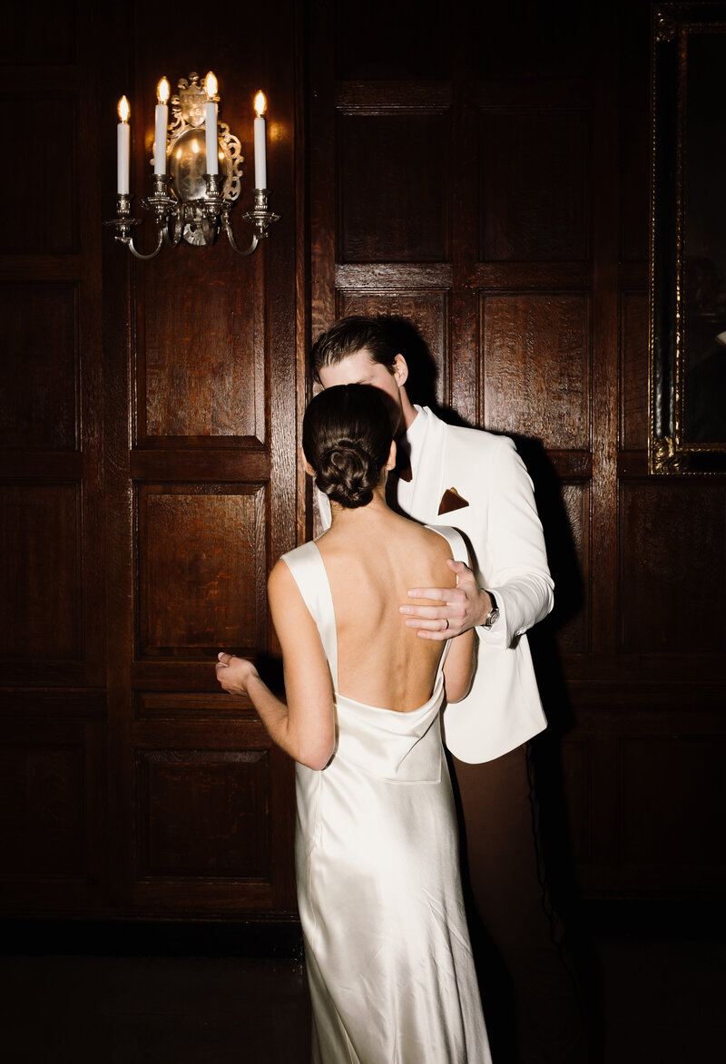Bride and groom kiss after cake cutting at the Harvard Club in Boston. Boston wedding photographer