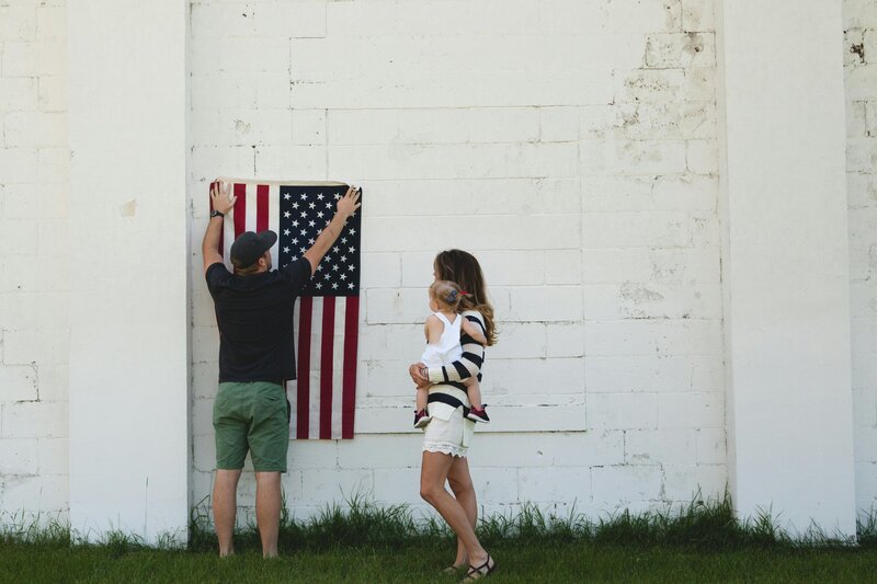 A military familly holding up an american flag