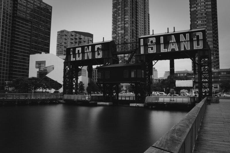 Long Island City waterfront sign, representing Molly Curry's local roots and urban coaching environment.