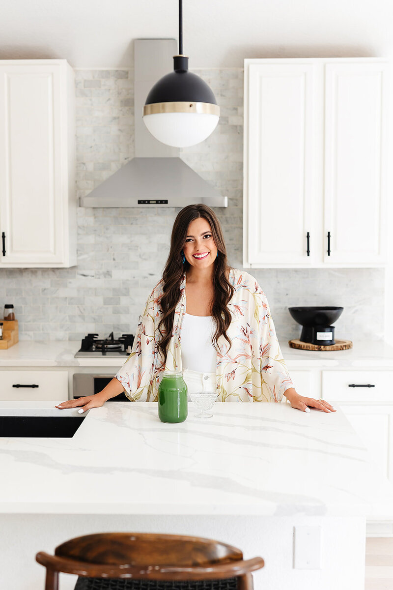 Abby Manawes standing in a kitchen with celery juice on the counter