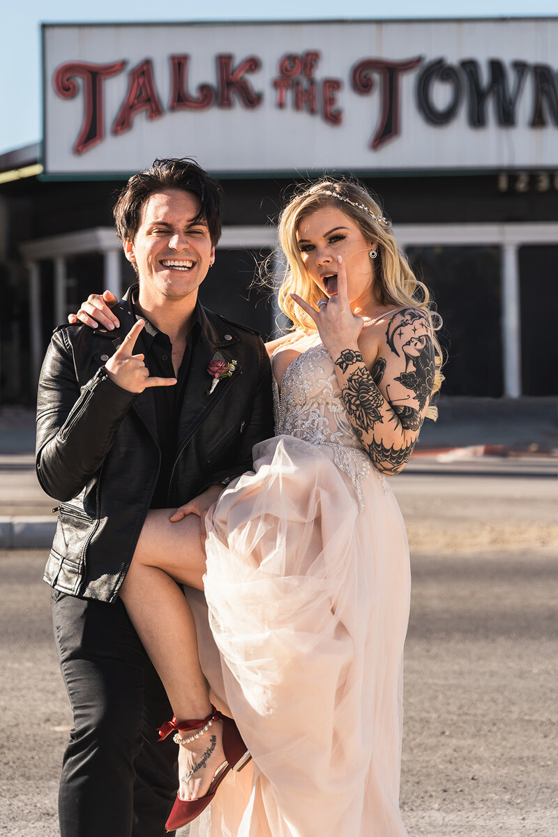 a tattoo bride and groom giving rock signs after getting married in las vegas new york