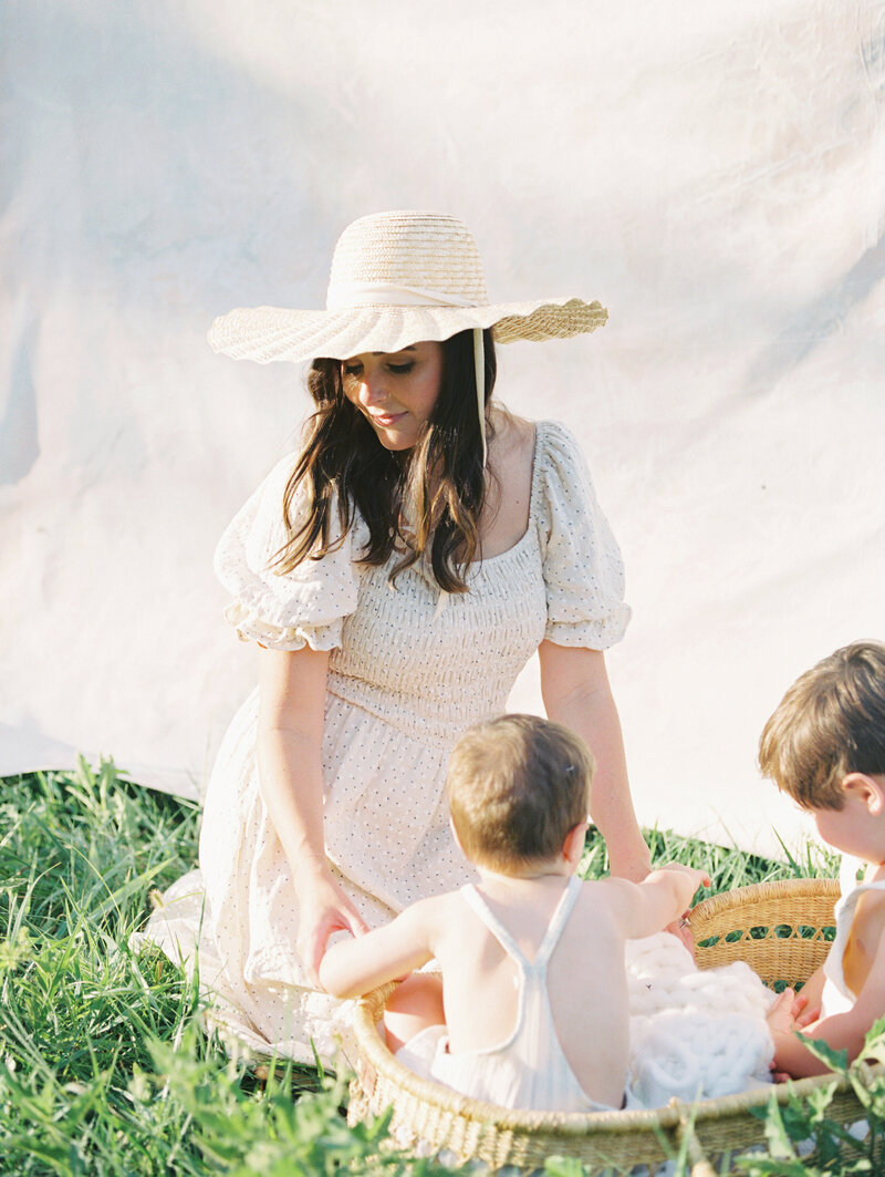 Film image of mother interacting with her sons in a field with a backdrop