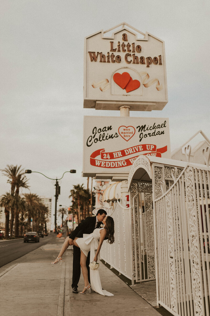 couple sitting on bridge with frenchie