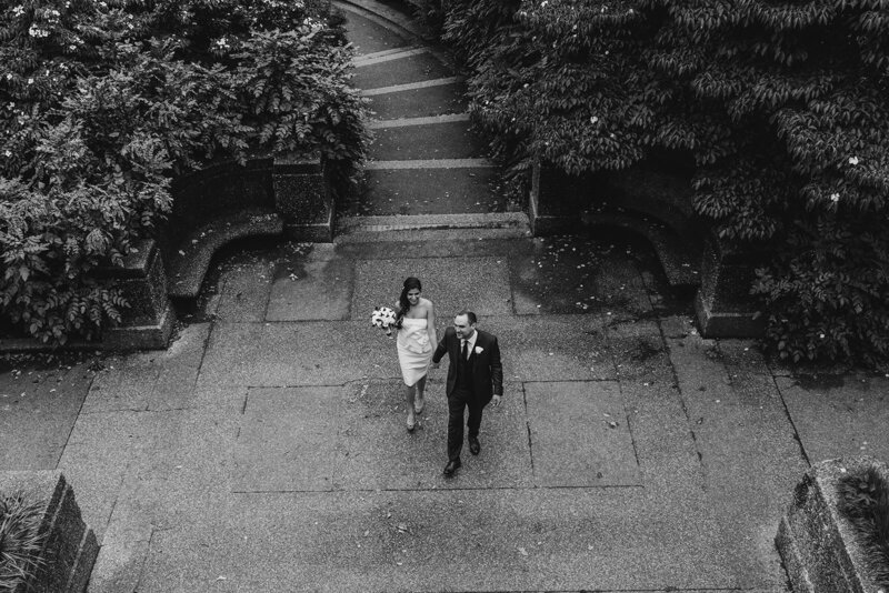 View looking down at a newlywed couple holding hands and walking together 