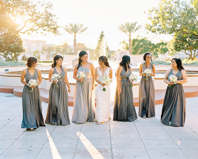 4-radiant-love-events-bride-center-3-bridesmaid-on-each-side-of-her-grey-dresses-in-front-of-water-fountain-outdoor-romantic-elegant-timeless